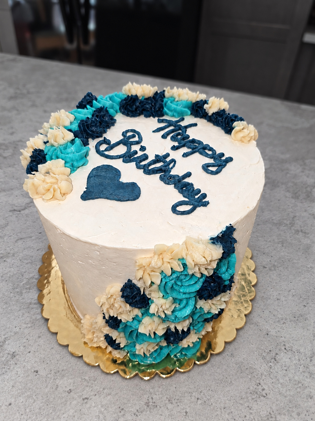 Vanessa’s birthday cake with turquoise, navy, and ivory buttercream flowers