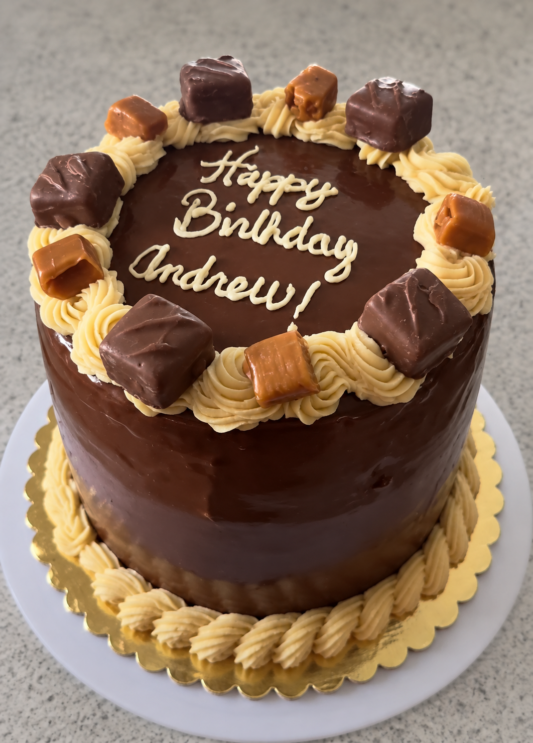 Chocolate ganache cake with caramel-colored buttercream and birthday lettering
